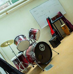 Salón del taller de música con batería y guitarras
